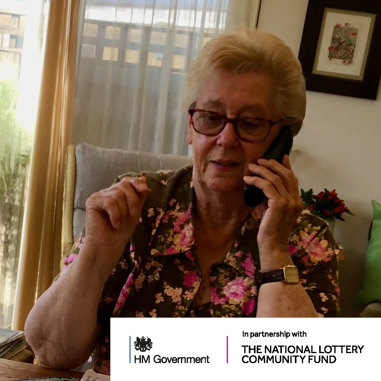 Person on the telephone with National Lottery Funding logo