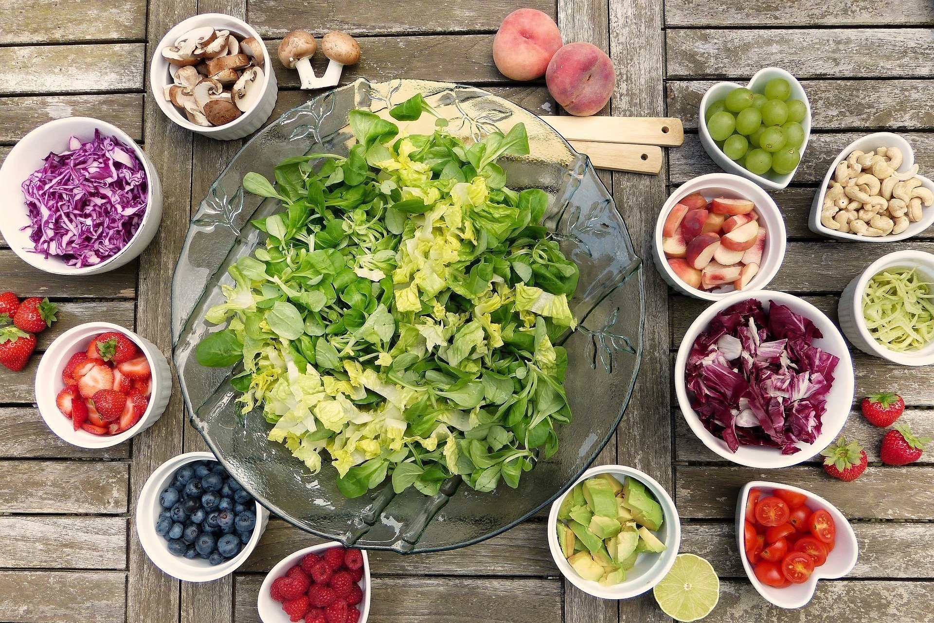 healthy salad and fruits presented in bowls on a table