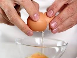 Egg being broken over a bowl