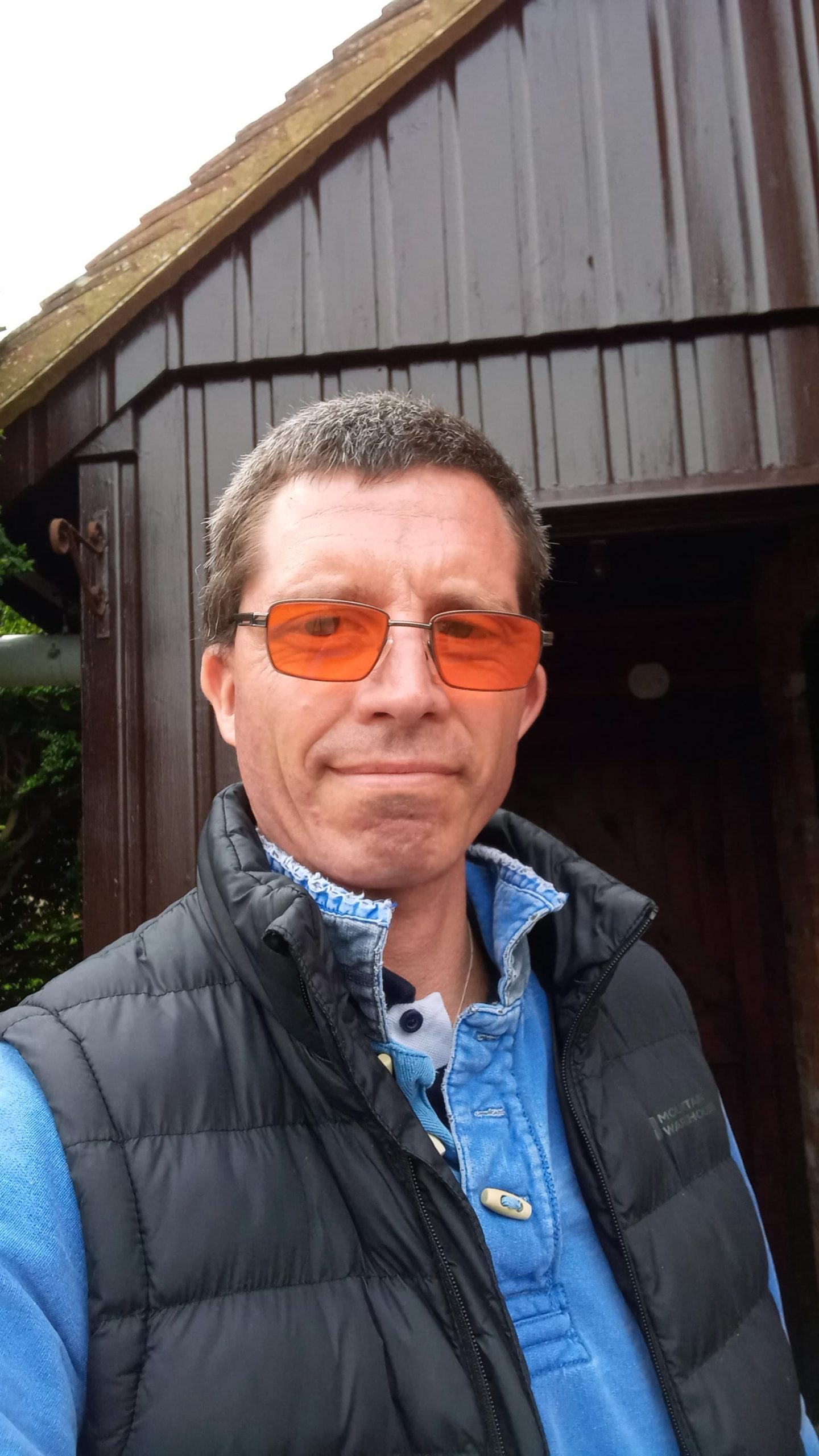 James Hart smiling in his orange tinted glasses