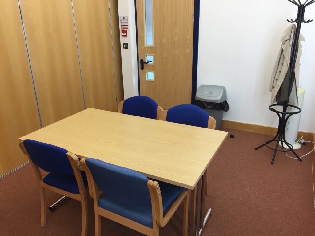 Small meeting room with 4 chairs around a table