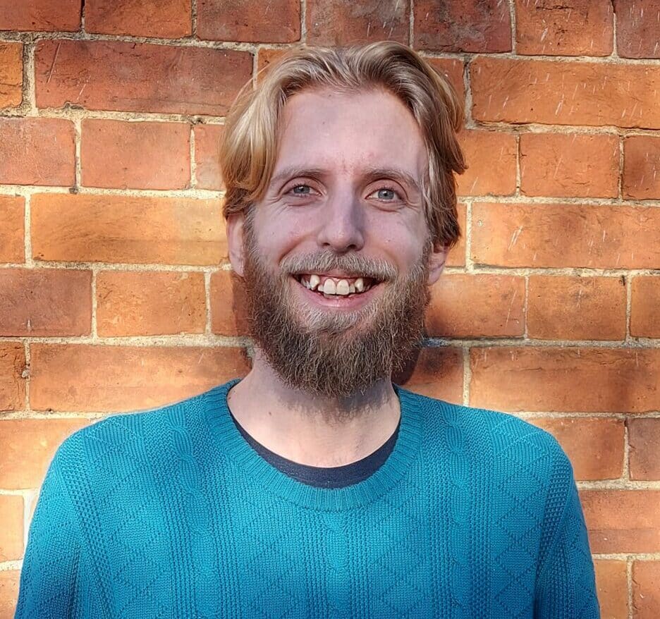 A photo of Arty in front of a brick wall.