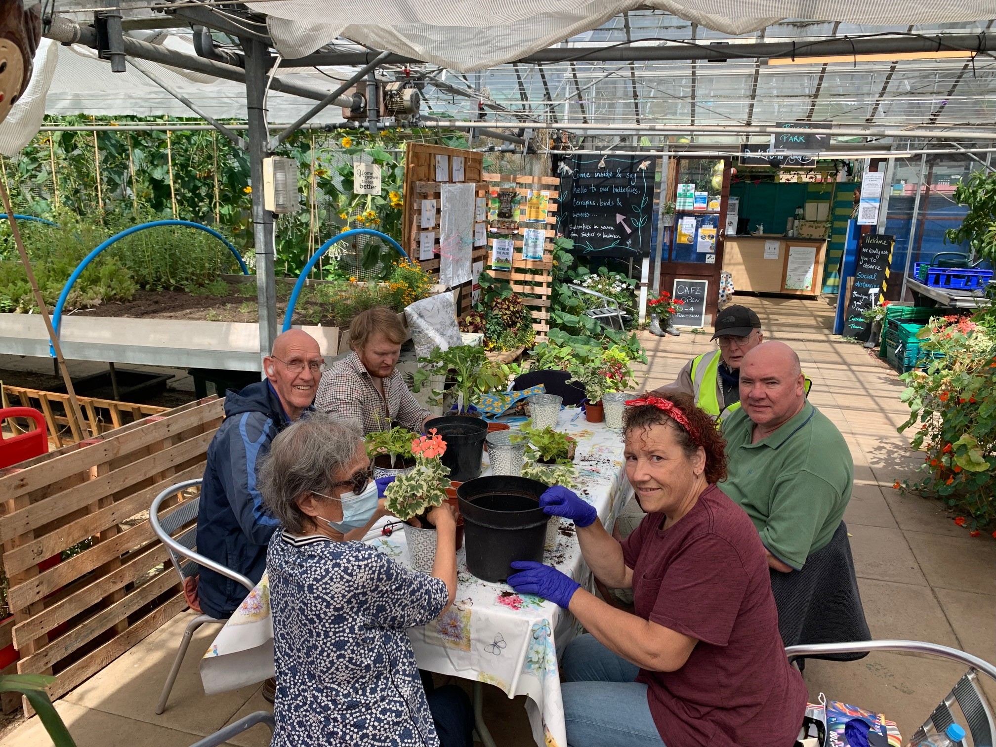 Cutteslowe Group posing for a photo at a table, surrounded by plants.