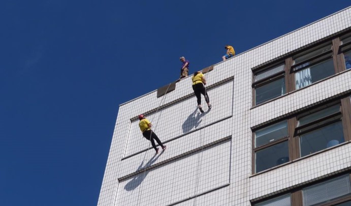 Two people abseiling down the John Radcliffe Hospital