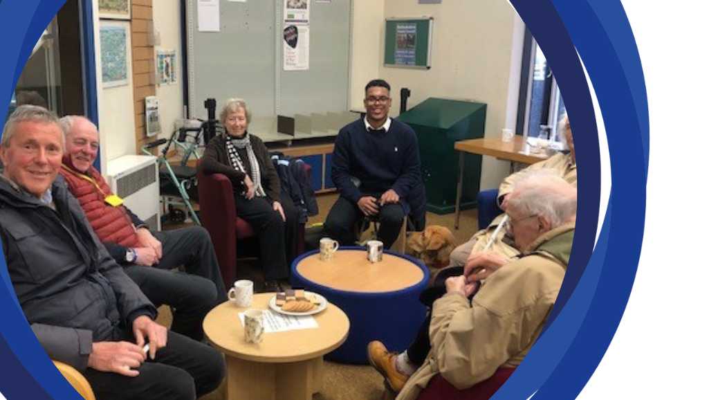 Henley social group gathered around a table and posing for a photo