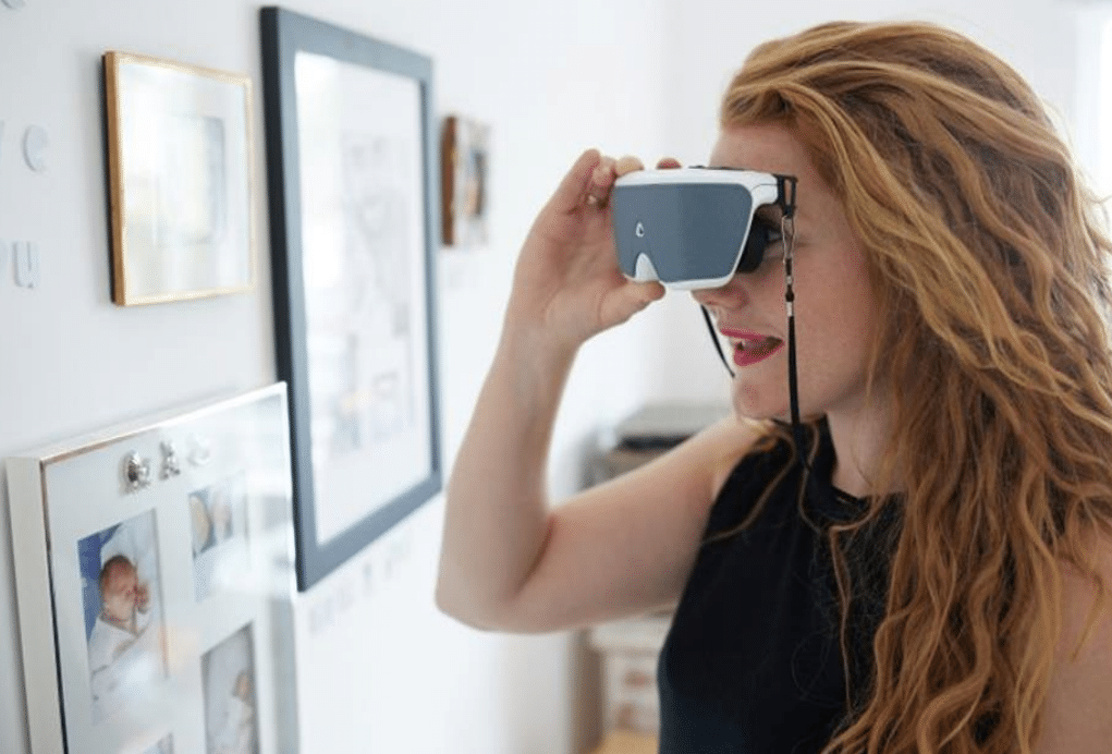 A lady wearing the Onyx glasses to look at photos on a wall