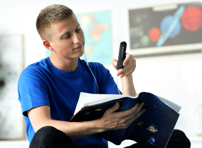 A person reading by pointing the OrCamRead at a book