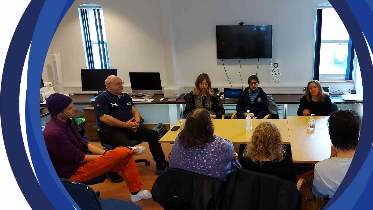 A group of people sitting around a table. Dr Jasleen Jolly is in the middle and there seven people around her.