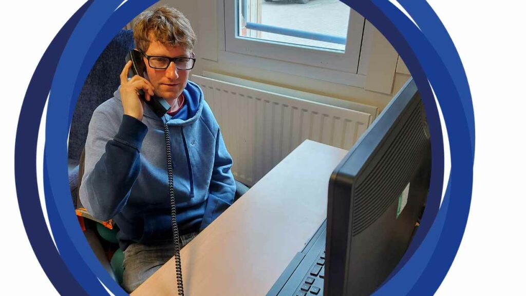 Mike, our counsellor sitting at a desk and talking on the phone.