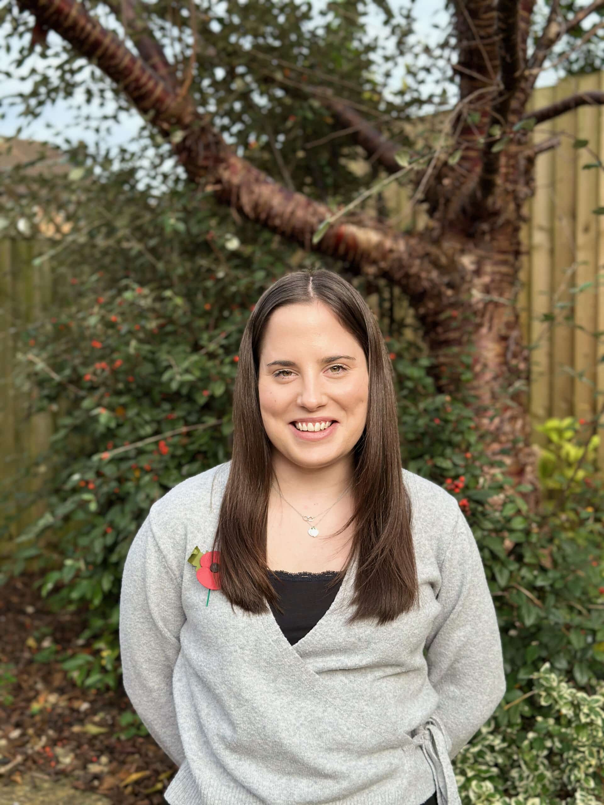 Katie standing in front of a tree