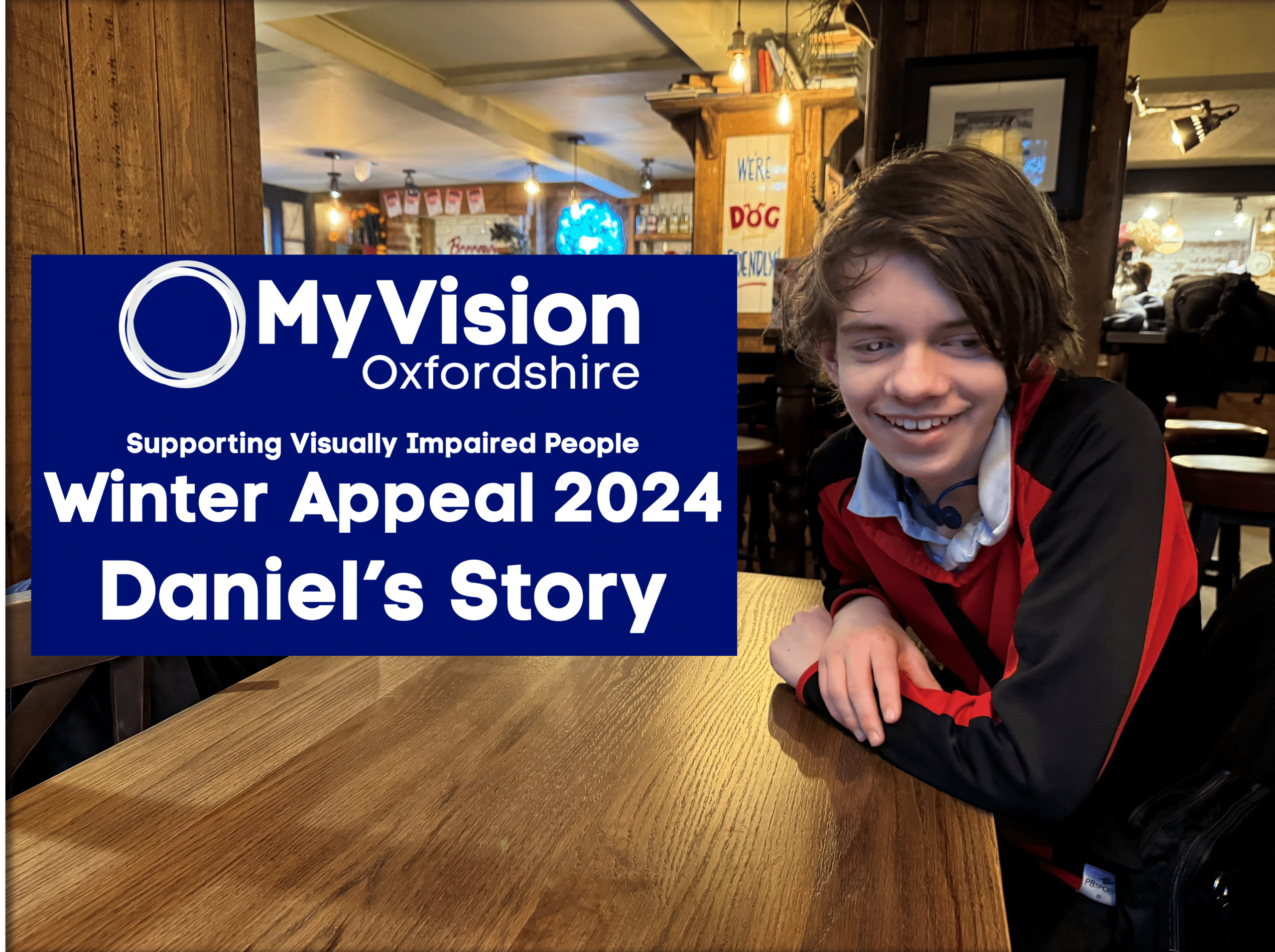 A photo of Daniel sitting at a table in a restaurant. He is looking at the camera and smiling. On the left, there is a blue square with the MyVision logo, and text reading 'Winter Appeal 2024 Daniel's Story'